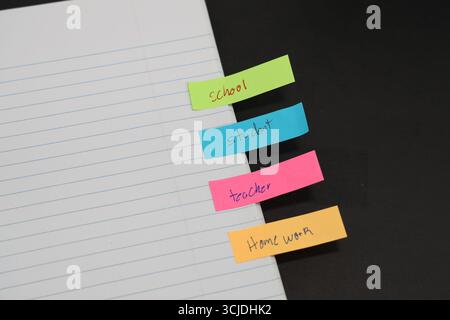sticky notes stuck to a school notebook written on them student teacher school homework Stock Photo