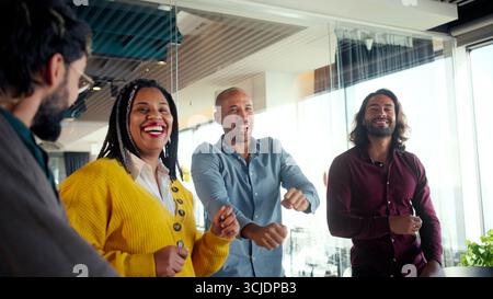 Diverse team celebrating in modern office Stock Photo