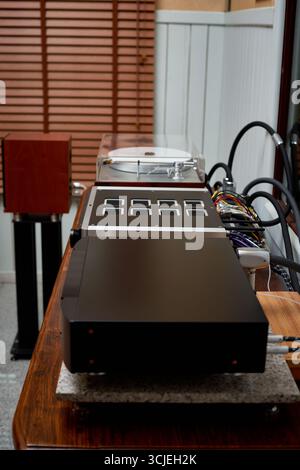 Sophisticated audio gear is arranged neatly in an intimate space, showcasing a turntable, control panel, and elegant wooden speakers, perfect for imme Stock Photo