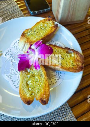 three garlic rolls with white bread on a plate, top view. Stock Photo