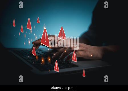 Person using phone and laptop is shown online with red warning signs indicating potential security threats. Cybersecurity technology, system warning o Stock Photo
