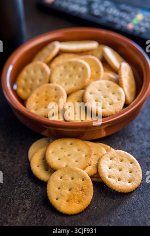 Crispy round salted crackers on a black table. Stock Photo