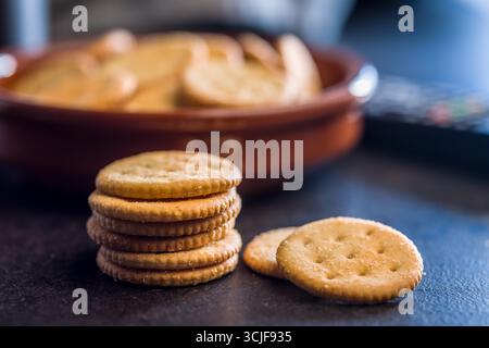 Crispy round salted crackers on a black table. Stock Photo