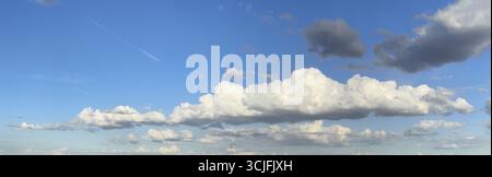 Panoramic photo of extended long wide stratocumulus white cloud cumulus clouds in front of bright blue sky, international Stock Photo