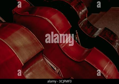 An image of three large double basses standing on a theater stage Stock Photo