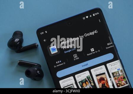 Smartphone displaying PhotoScan app page next to wireless earbuds Stock Photo