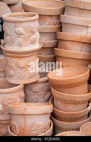 Italian clay terracotta flower and plant pots of different styles stacked in a shop for gardening and landscape design concept Stock Photo
