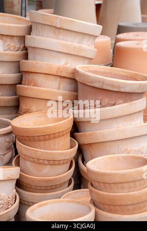 Italian clay terracotta flower and plant pots of different styles stacked in a shop for gardening and landscape design concept Stock Photo