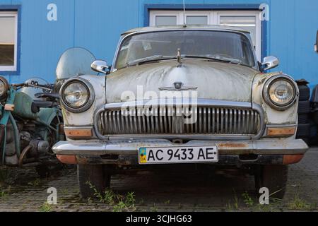 Wroclaw, Poland - August 28 2025: Moss-covered front of Soviet GAZ Volga with Ukrainian plate Stock Photo