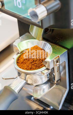 Ground coffee in portafilter ready for brewing, part of espresso preparation process in a coffee machine Stock Photo