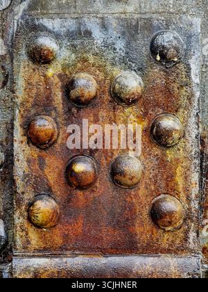 Large size bolts and nuts in iron and steel factories, old vintage rusty metal door Stock Photo