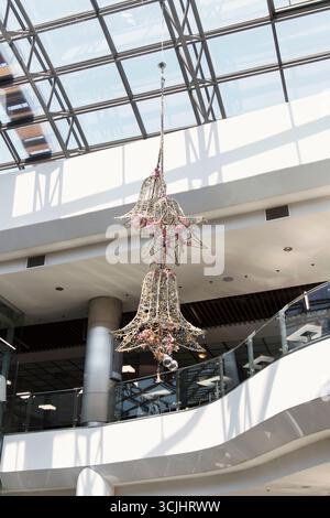 CHISINAU, MOLDOVA - IULY 6 A decorative beautiful bell-shaped chandelier made of woven materials, adorned with flowers and hanging crystals. It is dis Stock Photo