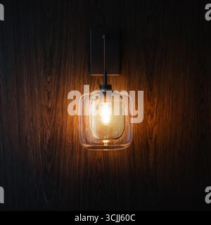 Light bulb on wooden wall. Edison-style bulb emitting warm light against brown wooden background. Stock Photo