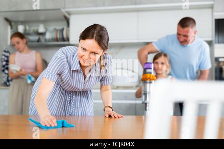 Mom is dusting the table. Father with children vacuuming room Stock ...