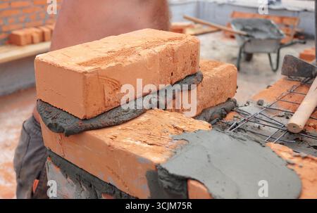 Bricklayer laying brick wall. Close up on bricklaying Stock Photo