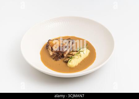 Roasted meat with mashed potatoes and brown sauce on plate Stock Photo