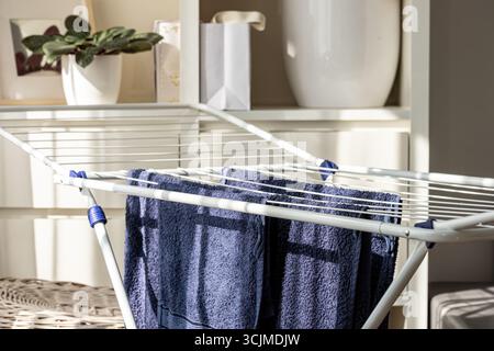 Neatly organized blue towels hang on a drying rack in a cozy indoor space, highlighting their soft texture and fresh appearance in a practical arrange Stock Photo