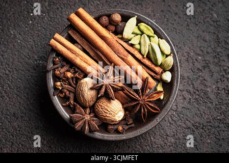 Traditional Christmas spices, extremely close up, top view. Cinnamon sticks, anise stars, cardamom, cloves and nutmeg for mulled wine. Aesthetic scent Stock Photo