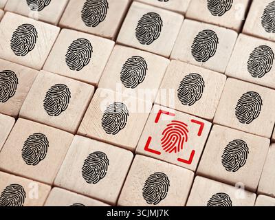 Biometric fingerprint scanner verifying identity on wooden blocks representing personal data protection Stock Photo