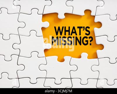 White jigsaw puzzle revealing the question what's missing? Problem solving, finishing a task and finding solutions concept. Stock Photo