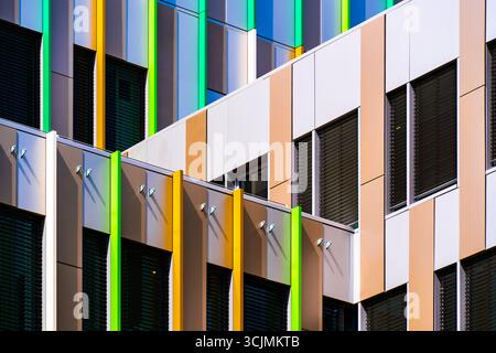 Colorful office facade with vertical green and yellow panels adding rhythm, contrast, and architectural vibrancy. Stock Photo