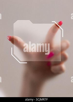 Graphic composition. Hand with pink nails holding transparent digital folder icon in futuristic interface Stock Photo