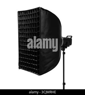 A professional studio softbox light with a honeycomb grid attachment on a stand isolated on a white Stock Photo