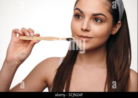 Beautiful dark haired woman holding toothbrush in studio Stock Photo