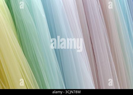 Vertical folds of translucent fabric in various pastel colors, close up shot, abstract textile background Stock Photo