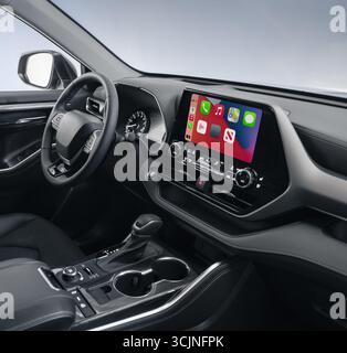 Front panel of modern vehicle, close-up shot of infotainment system. Apple CarPlay main screen menu in big spacious car. Stock Photo