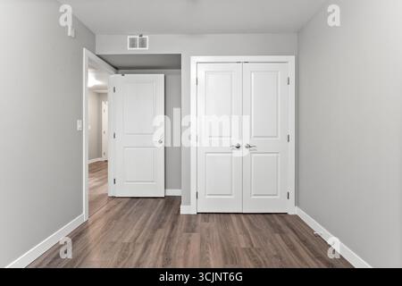 White room with a door leading to another room. The door is open and the room is empty Stock Photo