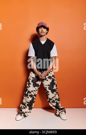 A stylish young man sports trendy clothes and a cool hat in an artistic scene. Stock Photo