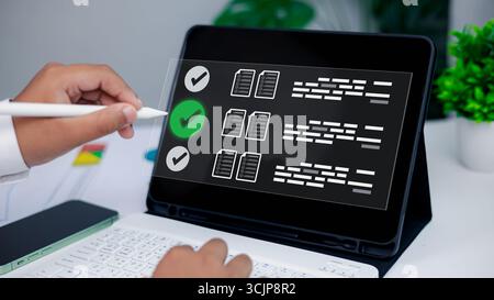 Close-up hand using stylus on tablet digital checklist interface, symbolizing task management, productivity tools, workflow efficiency, and modern tec Stock Photo