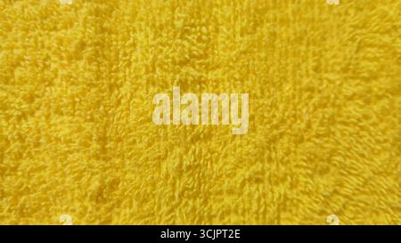 Close-up of soft yellow terry cloth towel texture background for cleaning and comfort concepts Stock Photo