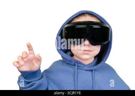 Child in blue hoodie and black virtual reality helmet touching virtual screen with finger on white background Stock Photo