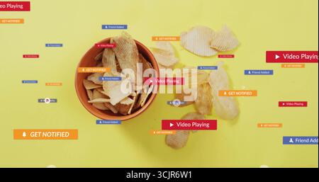 Displaying round bowl of ridged chips sitting on yellow surface, with floating pop-up labels Stock Photo