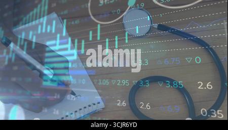 Hand using metallic pen noting on notebook at desk with stethoscope, stock data overlay, copy space Stock Photo