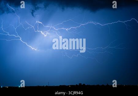 Lightning bolts illuminate the dark stormy night sky Stock Photo