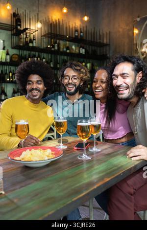 Happy multiracial business colleagues having a drink after work at brewery bar Stock Photo