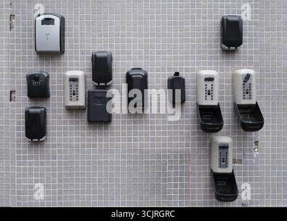 Multiple Key Lock Boxes Mounted On Outdoor Tiled Wall Used For Secure Storage And Access Control In Real Estate And Property Management Stock Photo