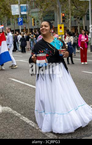 October 12, 2024, Barcelona (Spain). Members of a folk group wearing multi-colored traditional costumes pose at the Hispanic Day in Barcelona. Stock Photo