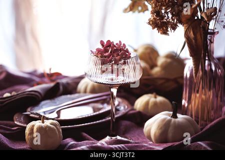 Cozy autumn dining table with pumpkins and rustic tableware Stock Photo