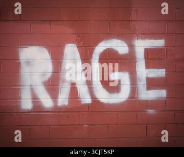 Graffiti Text Reading RAGE Spray Painted On A Red Brick Wall Stock Photo
