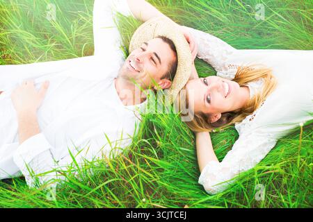 young couple lying head to head happily in a meadow Stock Photo