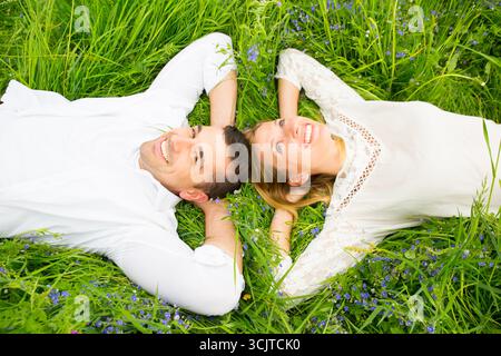 young couple lying head to head happily in a meadow Stock Photo