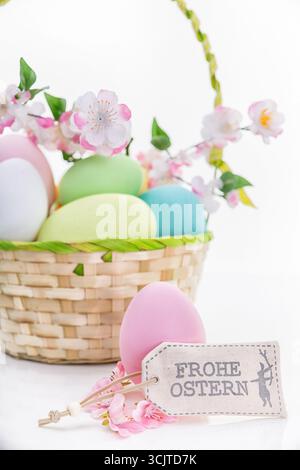 basket with Easter eggs, cherry blossoms and tag Happy Easter, Freisteller, Composing Stock Photo