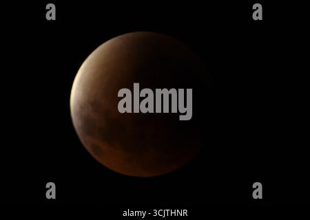 Melbourne, Victoria, Australia. 8th Sep, 2025. The full moon returns to the partial eclipse phase after its total eclipse during the phenomenon of the Blood Moon Total Lunar Eclipse as seen in Melbourne City, Victoria. Full moon painted in red is seen as the second total lunar eclipse of the year where moon sits deep within Earth's darkest part of our planet's shadow creating a dramatic ''blood moon'' A blood Moon total lunar eclipse was visible on 7/8 September 2025. Observers based in Pakistan, India, China, Russia, Australia and New Zealand, east Africa and the regions surrounding centr Stock Photo
