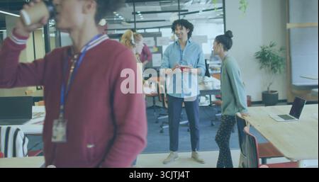 Holding red coffee mug, Hispanic man wearing blue shirt in open-plan office, with sticky notes Stock Photo