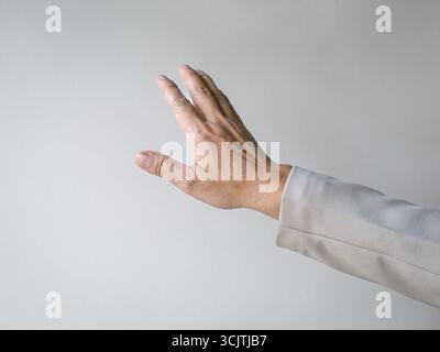 Man reaching out his hand as though touching something. Isolated on white background, copy space. Stock Photo