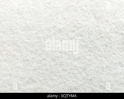 White soft woolen texture background, close-up of light-colored felt fabric. Stock Photo